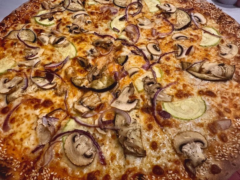 Close crop of a mushroom and onion pizza, crust to crust