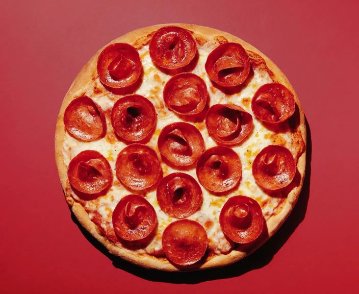 A whole pepperoni pizza with cupped salami on melted cheese