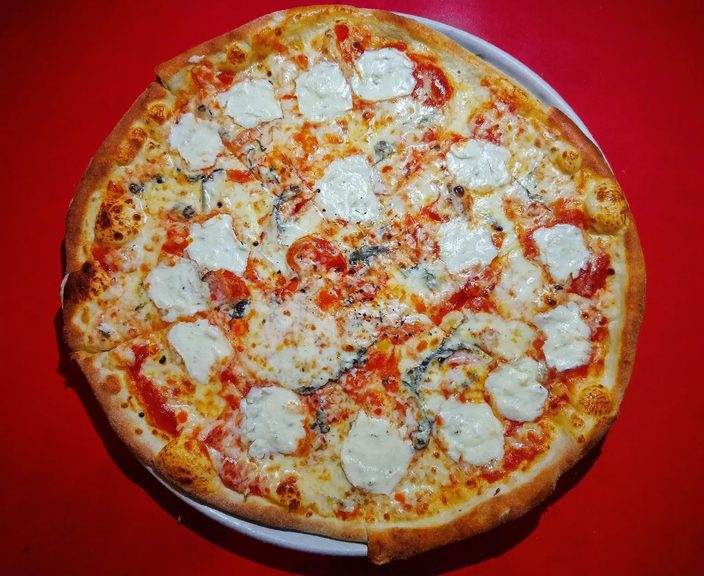 A whole four-cheese white pizza with a golden crust